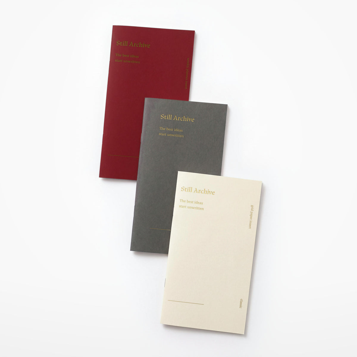 The three planner inserts cascaded, showing the gold foil cover of each